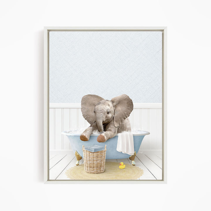 A baby elephant sitting in a bathtub, surrounded by a basket, a towel, and a rubber duck.