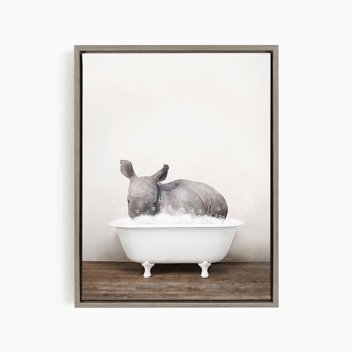 A rhinoceros is sitting in a white bathtub filled with water, creating a whimsical and playful scene.