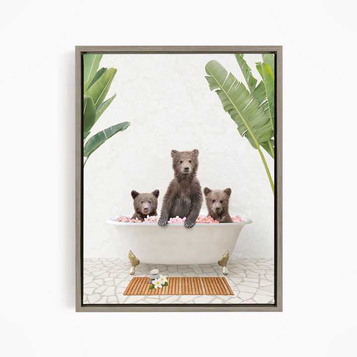 A framed image depicting three bears sitting in a bathtub filled with pink flowers, surrounded by green leaves.
