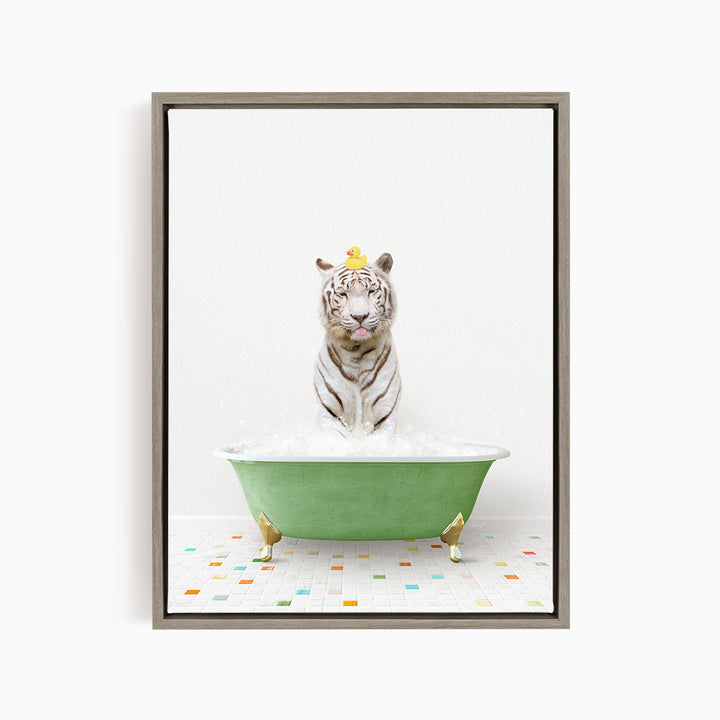 A white tiger is sitting in a green bathtub filled with bubbles, wearing a yellow duck hat.