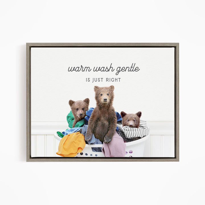 three bears sitting in a laundry basket, with one bear sitting on top of clothes and the other two bears sitting on the clothes.