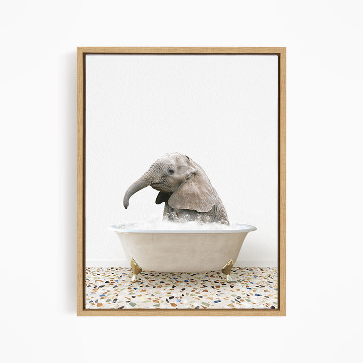 A baby elephant sitting in a white bathtub filled with water, with its trunk submerged in the water.