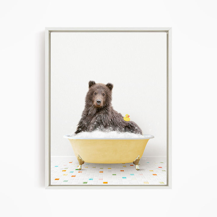 A brown bear sitting in a yellow bathtub, with a rubber duck floating in the water.