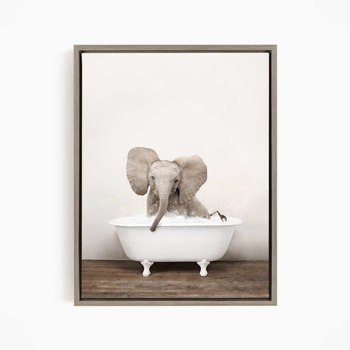A baby elephant sitting in a white bathtub filled with water, with its trunk submerged in the water.