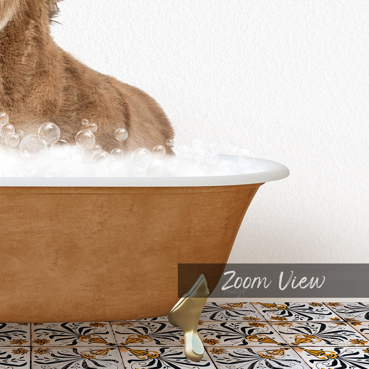 A brown dog is sitting in a bathtub filled with bubbles, with a gold bathtub leg visible on the floor.