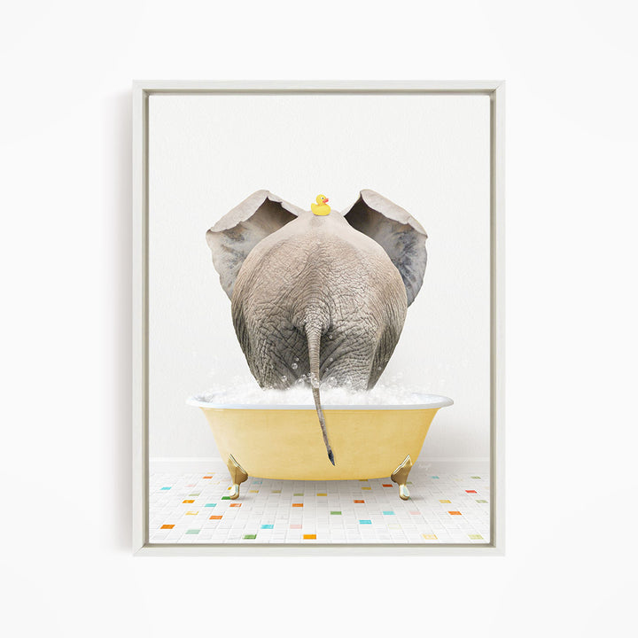 A gray elephant is standing in a yellow bathtub filled with bubbles, with a yellow rubber duck perched on its head.