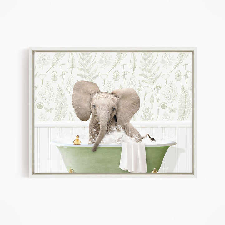 A gray elephant is sitting in a green bathtub filled with water, surrounded by a white wall with a pattern of leaves and ferns.