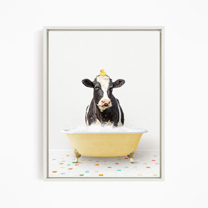 A black and white cow is standing in a yellow bathtub filled with water, with a yellow rubber duck perched on its head.
