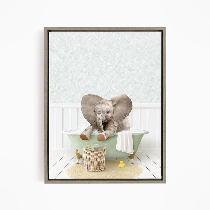 A baby elephant sitting in a green bathtub, surrounded by a basket of toys and a yellow rubber duck.