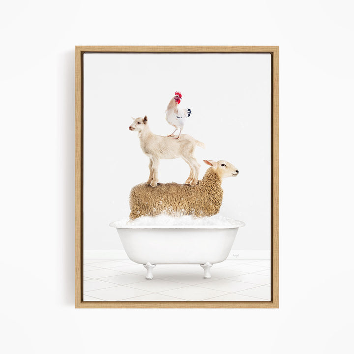 A framed image depicting a sheep standing on a goat's back, with a rooster perched on top of the goat, all in a white bathtub.