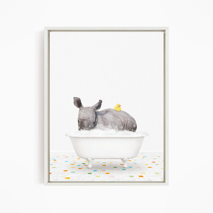 A rhinoceros is sitting in a white bathtub filled with water, with a yellow rubber duck floating on its back.