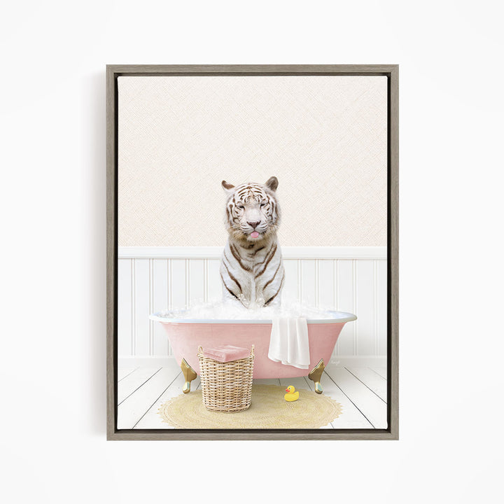 A white tiger is sitting in a pink bathtub filled with water, surrounded by a yellow rubber duck and a basket.