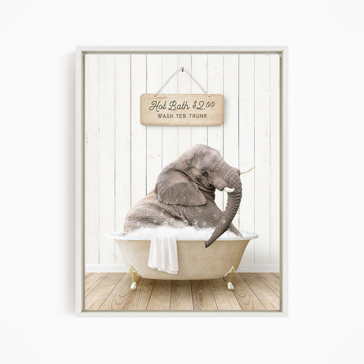 A gray elephant is sitting in a bathtub filled with water, with a sign above it that reads "Hot Bath $2.00 WASH YER TRunk".