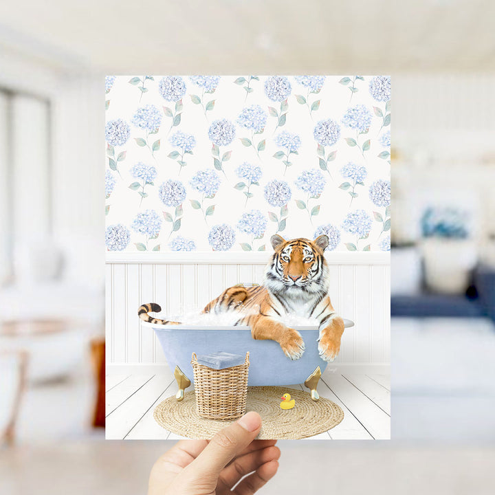A tiger is sitting in a bathtub filled with water, surrounded by a blue and white floral pattern on the walls.