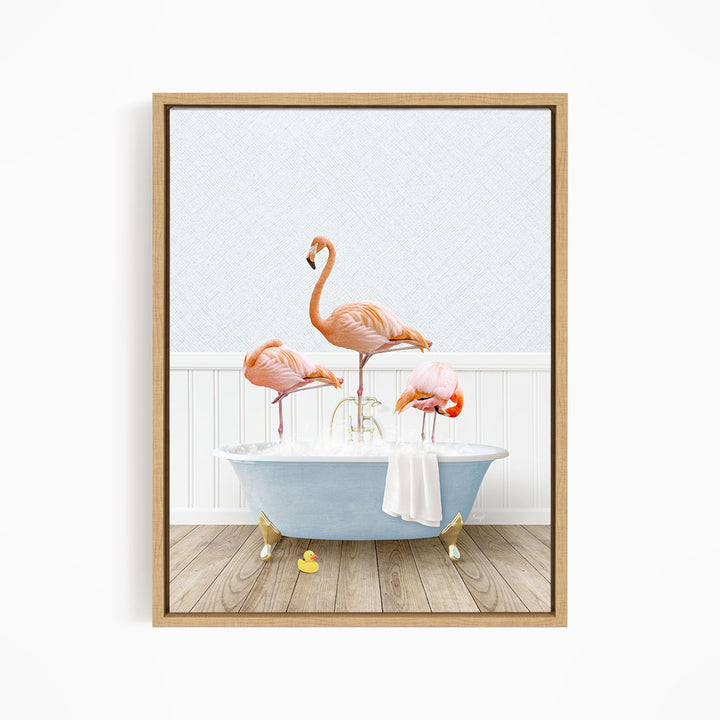A framed image depicting three flamingos standing in a bathtub filled with water, with a towel hanging on the side.