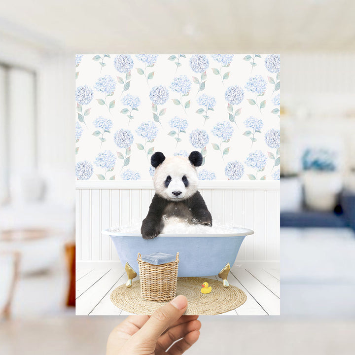 A panda bear sitting in a blue bathtub filled with bubbles, surrounded by a floral patterned wall.