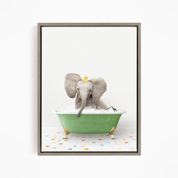 A gray elephant is sitting in a green bathtub filled with water, with a yellow rubber duck floating on its head.