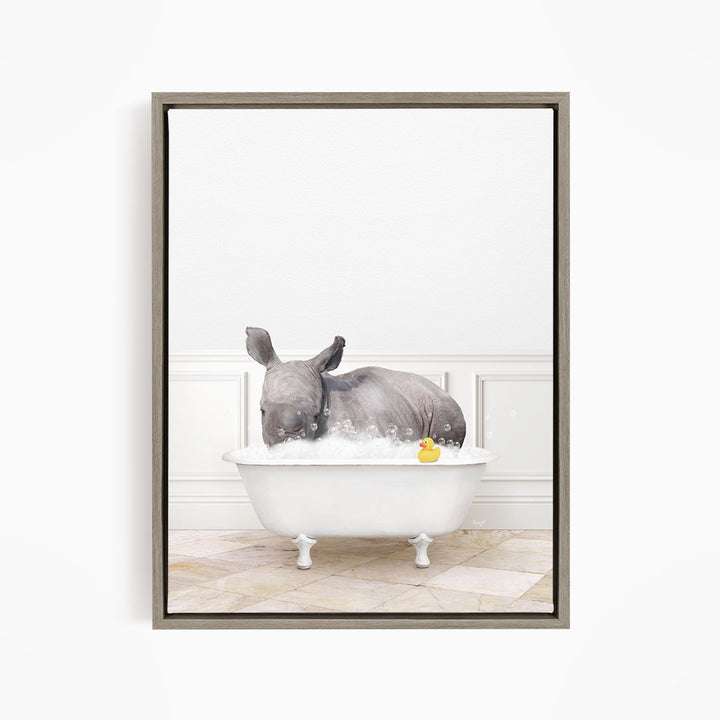A rhinoceros is sitting in a white bathtub filled with water, surrounded by bubbles, and holding a yellow rubber duck.