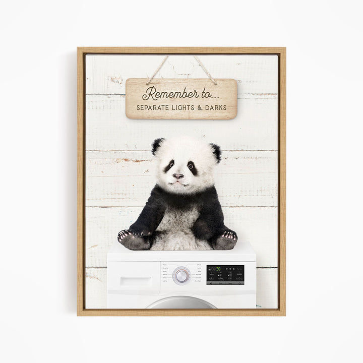 A panda bear sitting on top of a washing machine, with a wooden sign above that says "Remember to separate lights & darks".