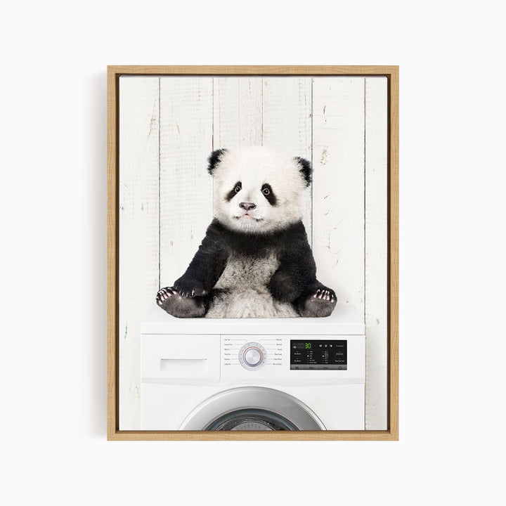 A panda bear sitting on top of a washing machine.
