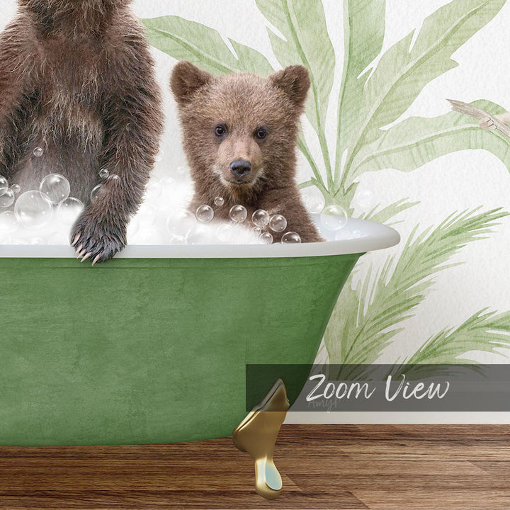 A baby bear sitting in a green bathtub filled with bubbles, with a palm tree wallpaper in the background.