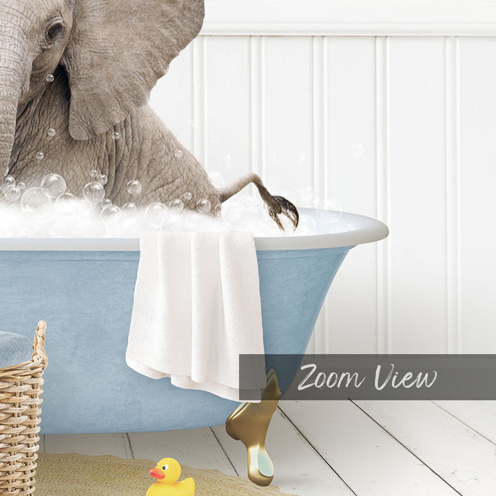 A large gray elephant is sitting in a blue bathtub filled with bubbles, surrounded by a yellow rubber duck and a towel.