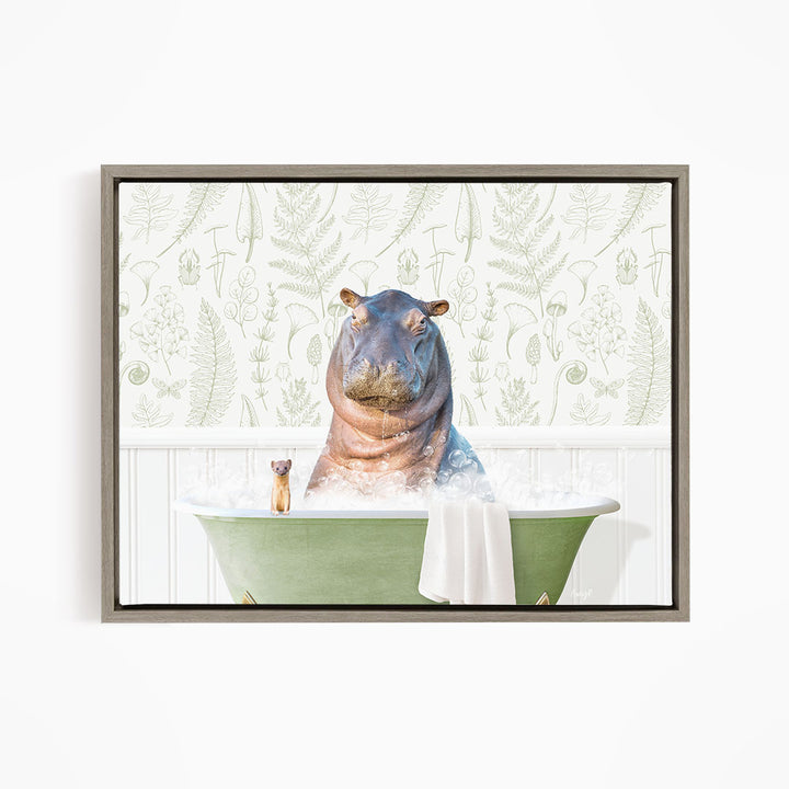 A hippopotamus sitting in a green bathtub, surrounded by a towel and a small cat, against a backdrop of a patterned wall.