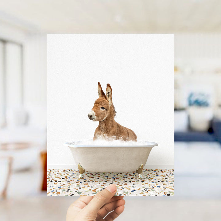 A donkey is sitting in a bathtub filled with water, creating a playful and whimsical scene.
