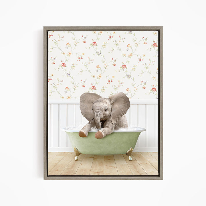 A baby elephant sitting in a green bathtub, with its trunk raised and ears spread out, against a floral wallpaper background.
