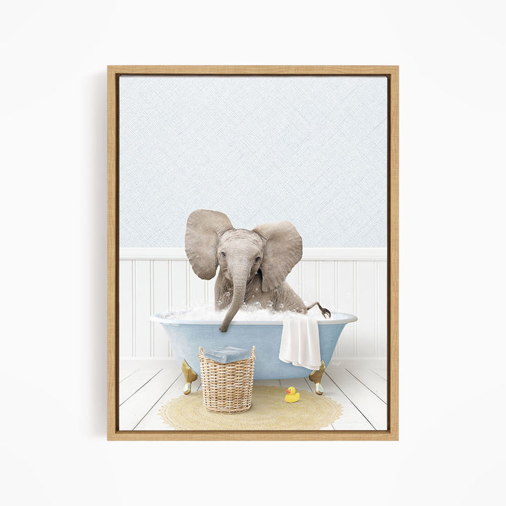 A baby elephant sitting in a blue bathtub, surrounded by a basket of toys and a yellow rubber ducky.