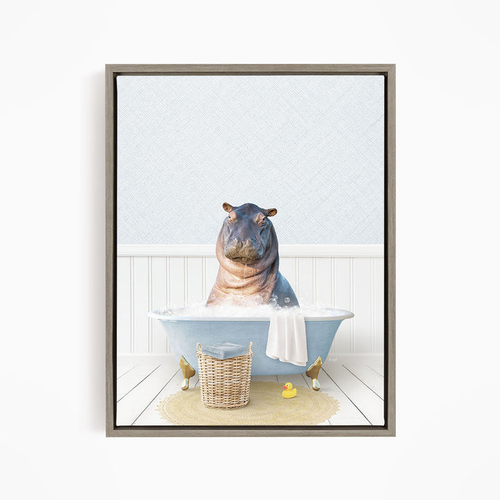 A hippopotamus sitting in a bathtub filled with water, surrounded by a basket of toys and a yellow rubber duck.