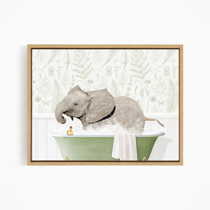 A gray elephant is sitting in a green bathtub filled with water, surrounded by a white towel and a yellow rubber duck.