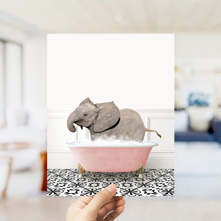 A gray elephant is sitting in a pink bathtub filled with bubbles, surrounded by a black and white patterned floor.