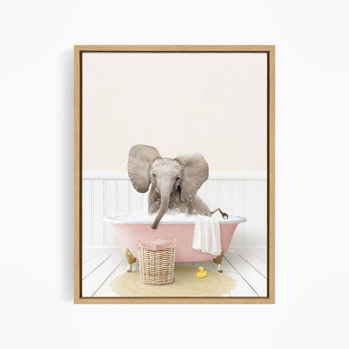 A gray elephant is sitting in a pink bathtub filled with water, surrounded by a yellow rubber duck and a basket.