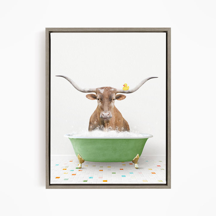 A brown cow with large horns is sitting in a green bathtub, with a yellow rubber duck perched on its head.