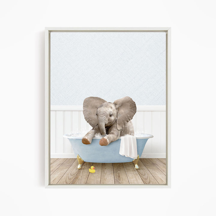 A baby elephant sitting in a blue bathtub, surrounded by rubber duckies, in a white-framed picture.