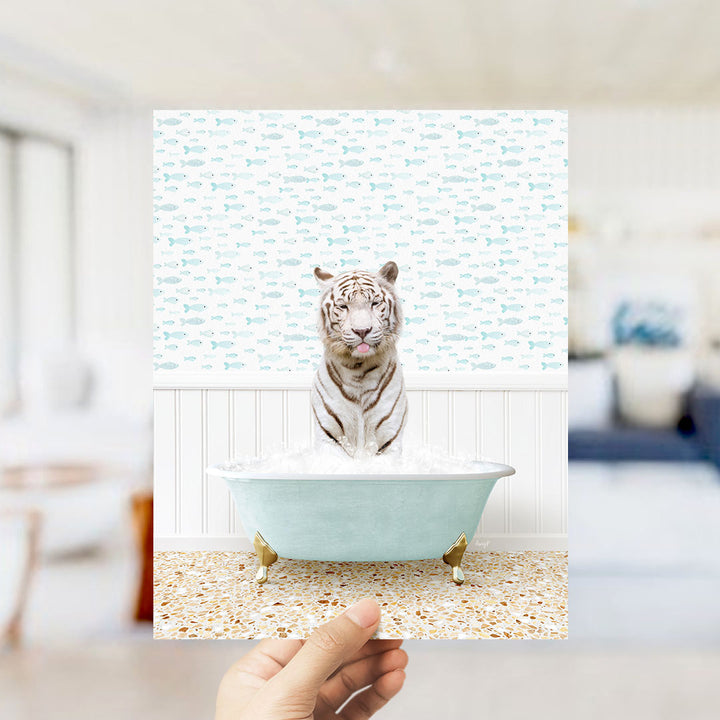 A white tiger is sitting in a light blue bathtub filled with water, surrounded by a pattern of small fish.