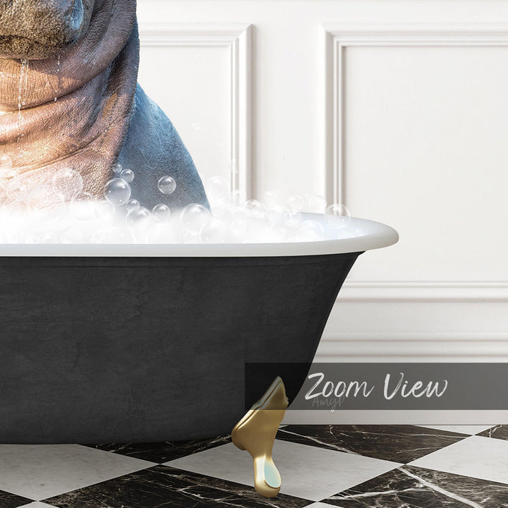 A black bathtub filled with bubbles, with a gold bathtub leg visible, and a white wall in the background.