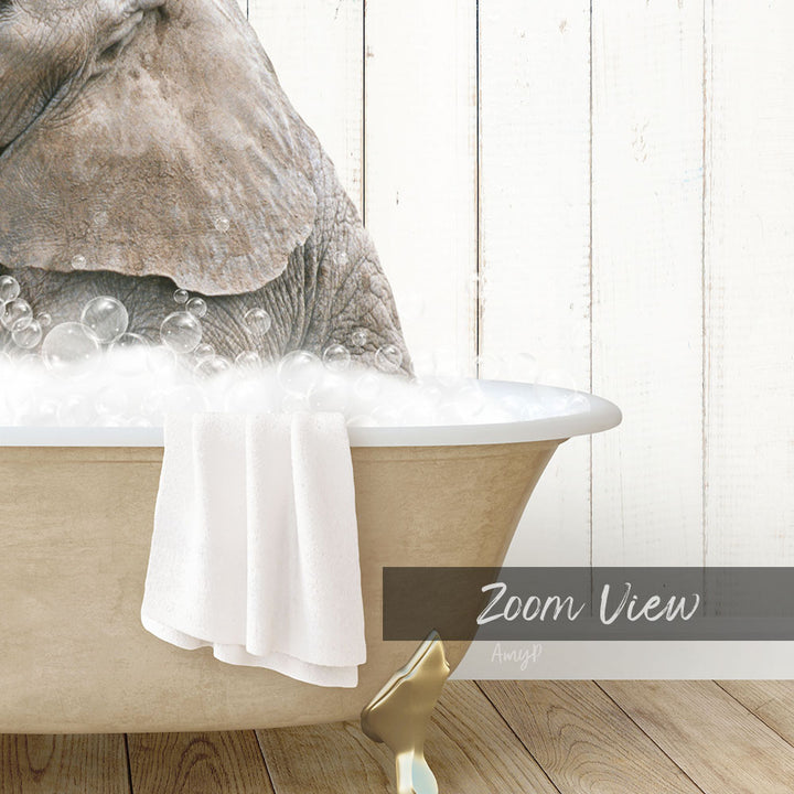 A large elephant is sitting in a bathtub filled with bubbles, with a towel draped over the side of the tub.