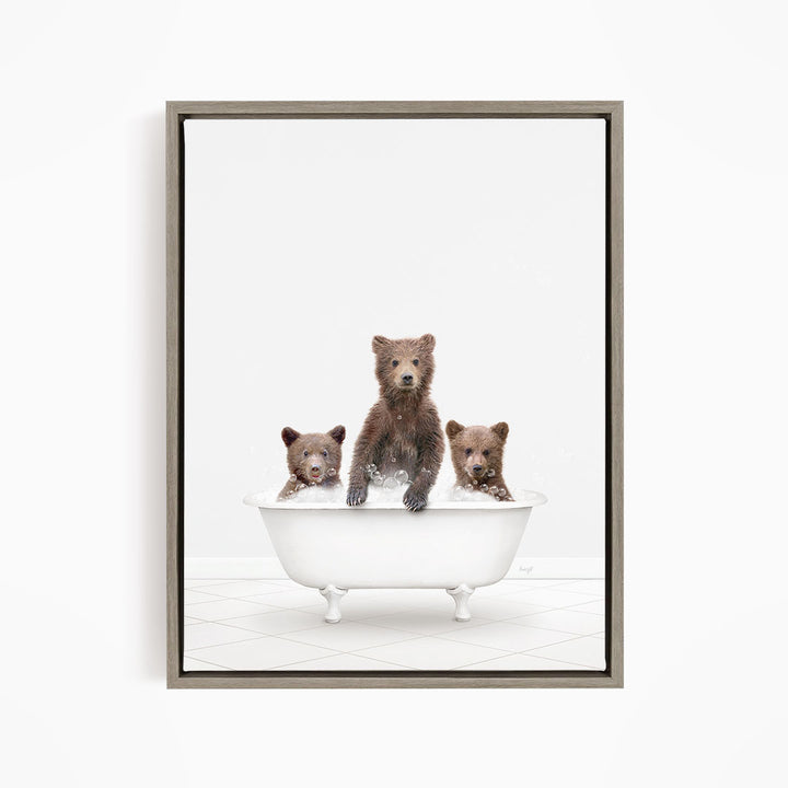 A framed image depicting three brown bears sitting in a white bathtub, with one bear sitting at the center and the other two bears sitting on either side.