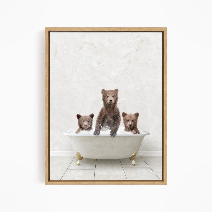 A framed image depicting three bears sitting in a white bathtub, with one bear sitting in the center and the other two bears sitting on either side.