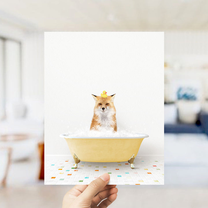 A fox is sitting in a yellow bathtub filled with bubbles, with a rubber duck perched on its head.