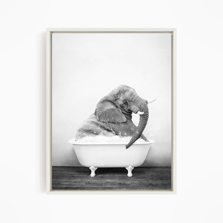 A large elephant is sitting in a white bathtub filled with water, creating a whimsical and playful scene.