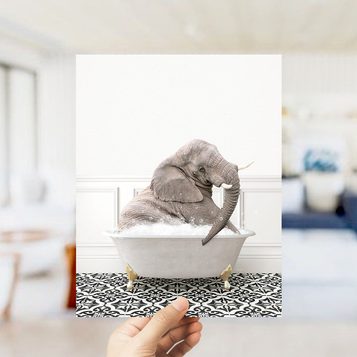A gray elephant sitting in a white bathtub filled with bubbles, surrounded by a black and white patterned floor.