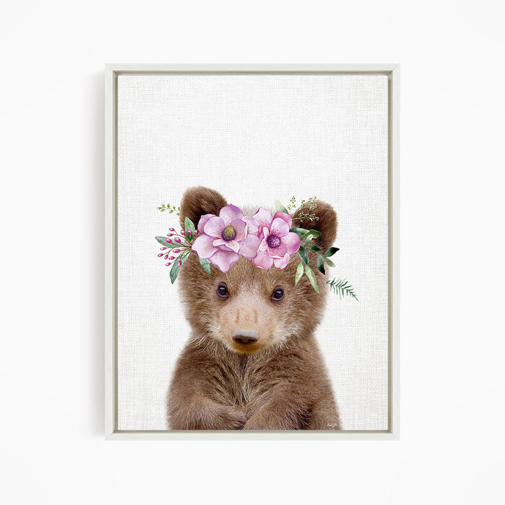 A cute brown bear wearing a floral crown on its head.
