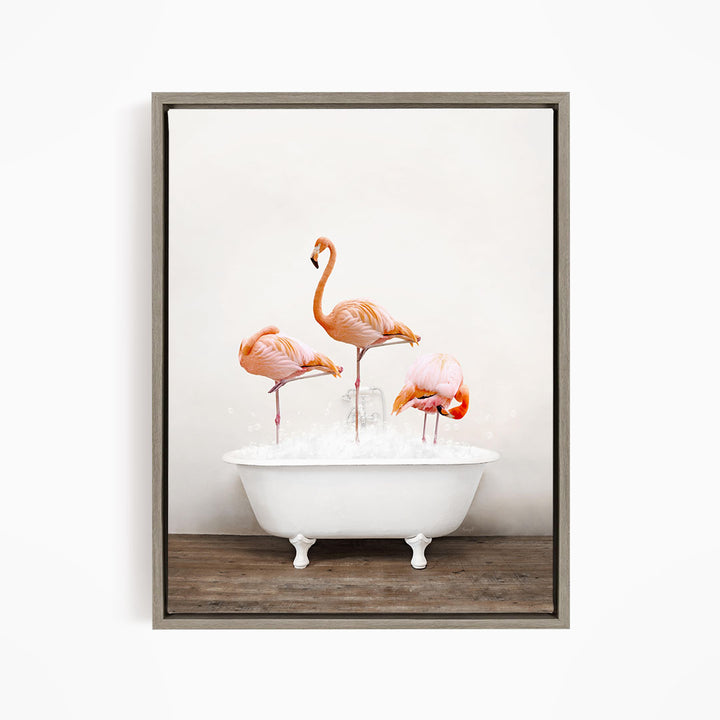 A framed image depicting three flamingos standing in a white bathtub filled with water.