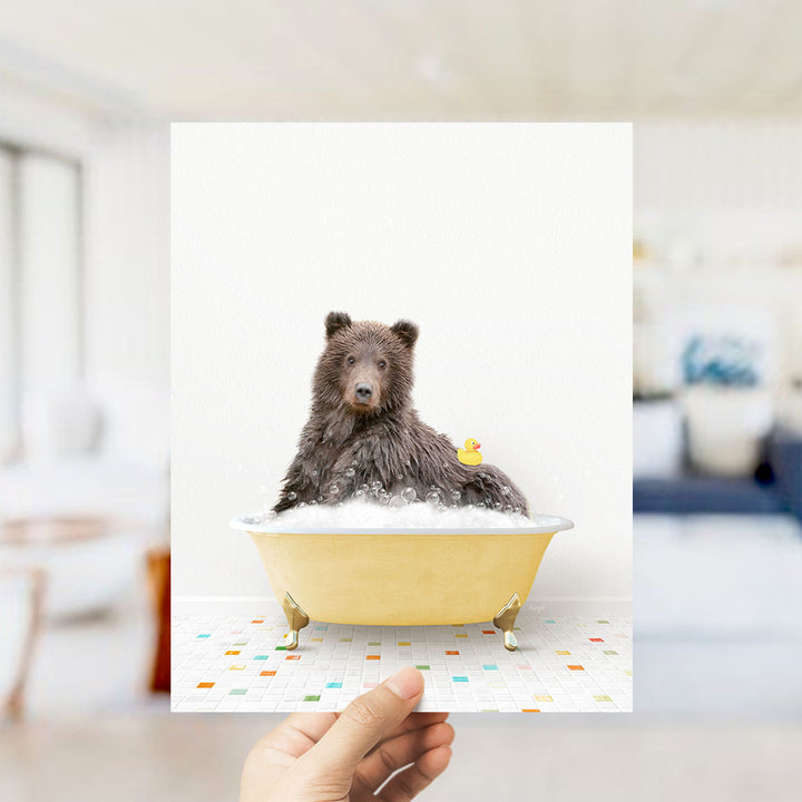 A brown bear sitting in a yellow bathtub filled with bubbles, with a yellow rubber duck floating nearby.