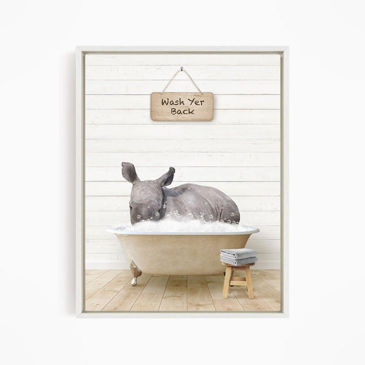 A rhinoceros is sitting in a bathtub filled with water, with a sign above it that says "Wash Yer Back".