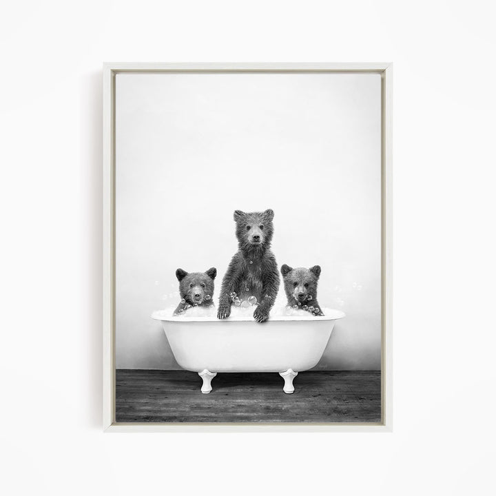 A black and white image of three bears sitting in a bathtub.