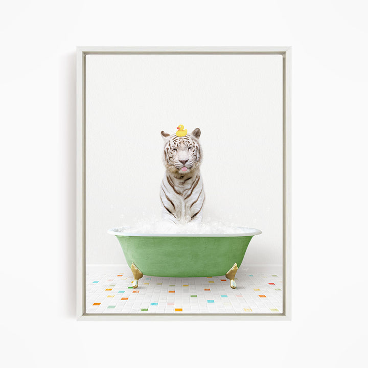 A white tiger is sitting in a green bathtub filled with bubbles, with a yellow rubber duck perched on its head.